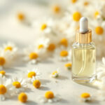 Fresh chamomile flowers with a small clear glass dropper bottle in soft morning light