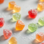 Assorted fruit gummies scattered on a pale surface in soft daylight